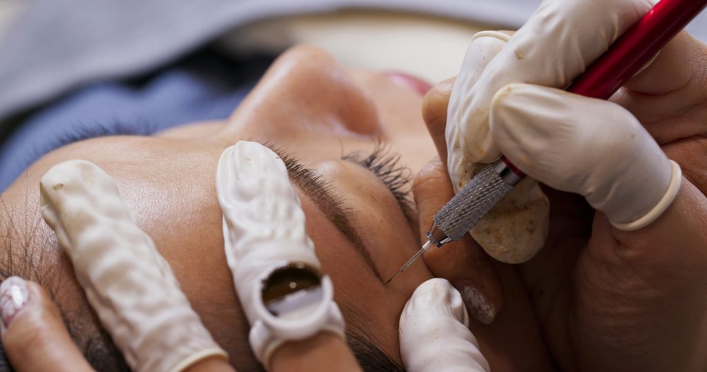 Asian woman gets facial beauty procedure, microblading procedure